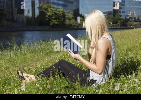 Teens in einem Buch in einer Wiese Stockfoto