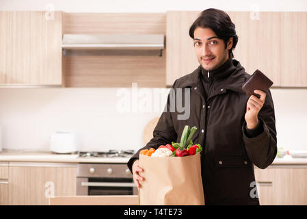 Junger stattlicher Mann mit Gemüse in der Küche Stockfoto