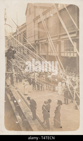 Jahrgang fotografische Postkarte zeigt eine große Gruppe von Menschen feiern, möglicherweise an einem Hafen. Stockfoto