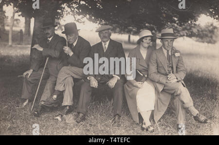 Jahrgang fotografische Postkarte zeigt eine Gruppe von britischen Menschen entspannend unter einem Baum Stockfoto