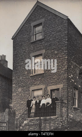 Jahrgang fotografische Postkarte zeigt ein Freistehendes 3-stöckigen British House. Die Hauseigentümer posiert vor dem Eigentum. Stockfoto