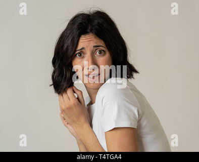 Nahaufnahme der jungen Frau mit erschrockenen Augen, schockiert, kauerte, zurückschrecken. Schaut entsetzt und verzweifelt. Menschen und die Ausdrücke und Gefühle c Stockfoto