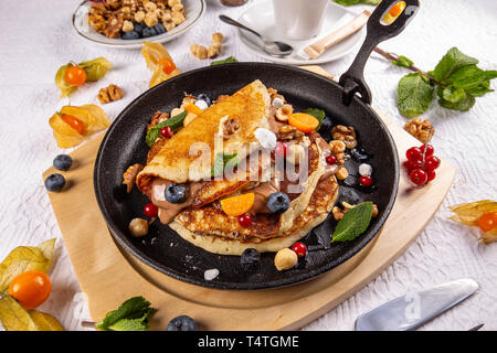 Original amerikanische Pfannkuchen mit Beeren, geröstete Nüsse und Schokolade Sauce Stockfoto