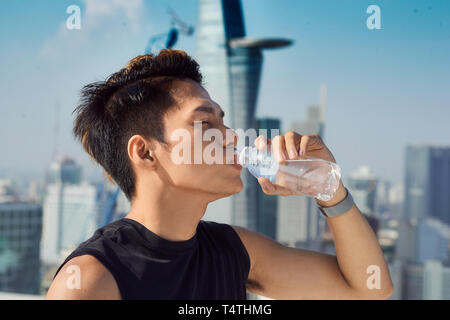 Nahaufnahme von einem Mann Wasser aus einer Flasche außerhalb Stockfoto