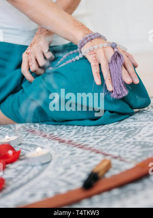 Frau mit lila mala Perlen auf Ihre Hände mit Henna mehendi Stockfoto