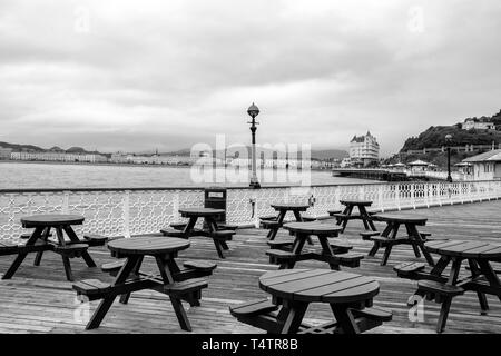 Auf der Suche nach Grand Hotel und Llandudno Promenade von Pier mit leeren Sitze in Schwarz und Weiß, North Wales UK Stockfoto