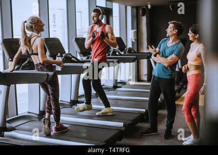 Gruppe von jungen Menschen in Sportswear sprechen in einer Turnhalle nach dem Training Stockfoto