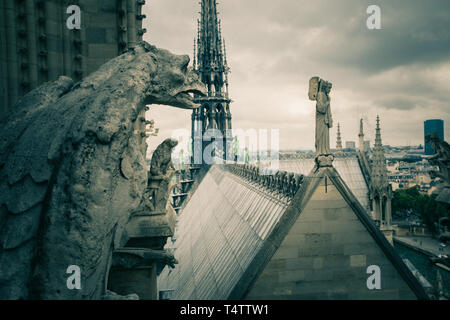 Dunkle Vintage-Optik der mythologischen Wasserspeier-Statue der Kathedrale Notre Dame auf der Pariser Skyline in Frankreich. Das Dach der gotischen Kirche Our Lady of Stockfoto