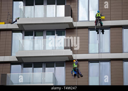 Arbeitnehmer mit Seil ein hohes Gebäude zu reinigen, steeplejack funktioniert. Bergsteiger wäscht Windows. Stockfoto