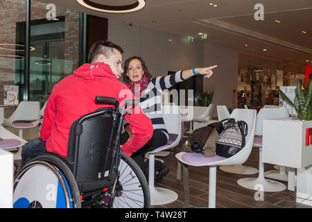 Mutter zeigt ihren behinderten Sohn etwas in der Ferne Stockfoto