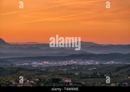 Blick über Weinberge in Wein Region Goriška Brda auf sunrise in die Stadt Nova Gorica mit der Julischen Alpen und des Triglav National Park in Slowenien in der Nähe der Grenze zu Italien in der Eu Stockfoto