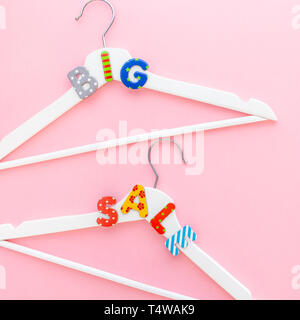Kreative, oben flach weiß Kleiderbügel große Verkauf text Pastell rosa Hintergrund Kopie Raum Minimalismus Stil. Vorlage Mode feminin Blog socia Stockfoto