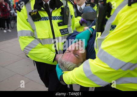 London UK 17. Apr 2019. Polizisten Anhalten ein Demonstrant in Parliament Square während des 3. Tag der Proteste vom Aussterben Rebellion Gruppe. Stockfoto