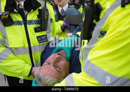London UK 17. Apr 2019. Polizisten Anhalten ein Demonstrant in Parliament Square während des 3. Tag der Proteste vom Aussterben Rebellion Gruppe. Stockfoto