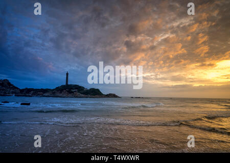 Anzeigen von Ke Ga Leuchtturm bei Sonnenuntergang mit der magischen Wolken. Ke Ga Leuchtturm auf einer kleinen Insel in Ninh Thuan Provinz, Vietnam Stockfoto