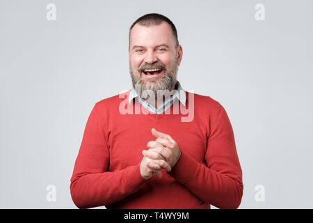 Schöne reife bärtiger Mann im roten Pullover lachen Stockfoto