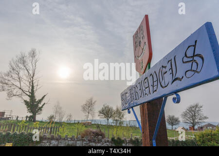 St Briavels Ortsschild in atmosphärischer Beleuchtung mit Sonnenuntergang im Hintergrund Stockfoto