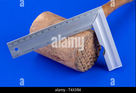 Holz- Hammer mit Winkel Herrscher auf blauem Hintergrund Stockfoto