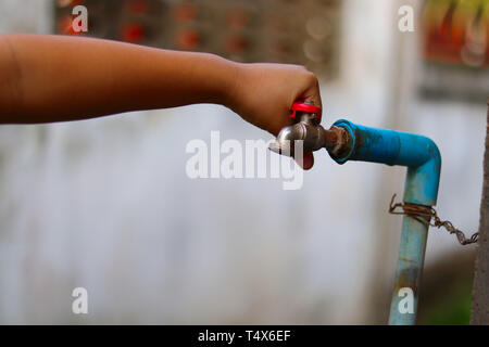 Junge Hände ausschalten Ein altes rostiges Wasser für Wasser sparen - Wasser sparen Konzept-ökologischen und ökologischen Konzept Stockfoto