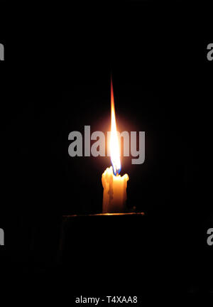 Brennende Kerze auf einem dunklen Stockfoto