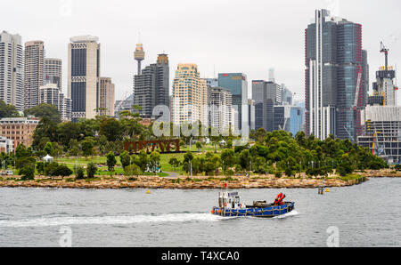 Eine funktionierende Boot übergibt Baragaroo finden im Hafen von Sydney, mit dem Sydney Skyline hinter sich. Stockfoto