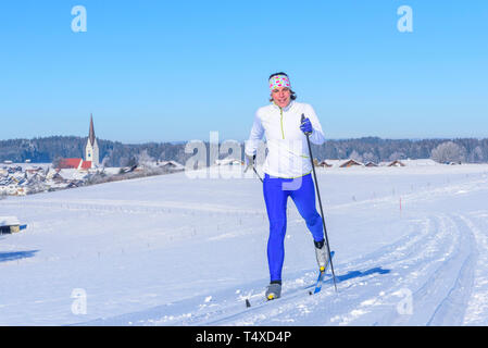 Skifahrerin, länderübergreifende Übung an einem sonnigen Wintertag Stockfoto