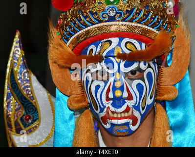 Junge taiwanesische Tänzer trägt traditionelle Taoistische Krieger Gesicht Farbe, eine prächtige Kopfbedeckungen und dramatische fake Augenbrauen. Stockfoto