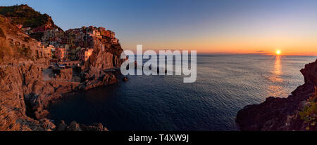 Panorama der Sonnenuntergang von Manarola, einer der fünf mediterranen Dörfer der Cinque Terre, Italien, bekannt für seine bunten Häuser und den Hafen. Stockfoto