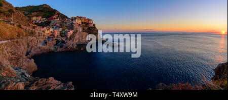 Panorama der Sonnenuntergang von Manarola, einer der fünf mediterranen Dörfer der Cinque Terre, Italien, bekannt für seine bunten Häuser und den Hafen. Stockfoto