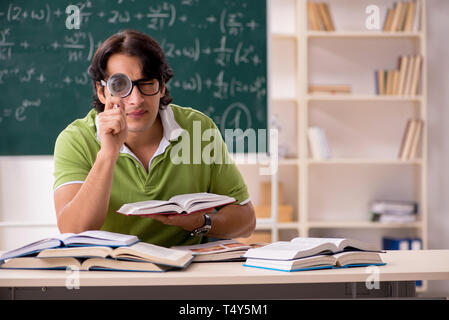 Gut aussehender Student vor der Tafel mit Formeln Stockfoto