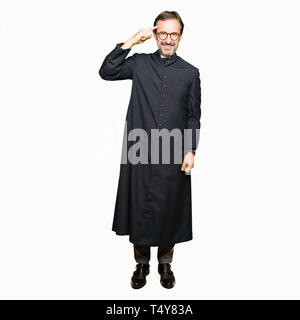 Mittleres Alter Mann, der katholische Priester robe Lächelnd zeigte mit einem Finger zu Kopf, tolle Idee oder gedacht, gutes Gedächtnis Stockfoto