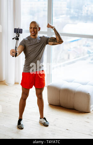 Junger Mann mit schönen athletischen Körper, die in der Nähe von selfie Fenster Stockfoto