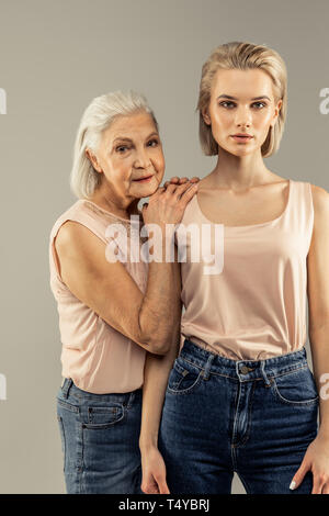 Positive nette Frau die Hände auf ihre Töchter Schultern Stockfoto