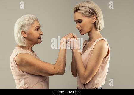 Angenehme junge Frau küsste ihre Mütter hand Stockfoto