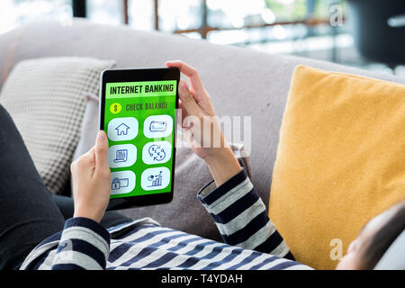 Internet banking concpet. Frau liegend auf dem Sofa mit Tablet mobile App für Pay Bill online zu Hause. digitaler Technologie Lifestyle. Stockfoto