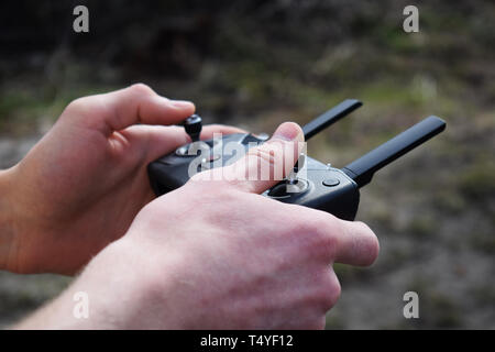 Remote Controller in männlichen Händen close-up. Mann mit Sender und Pilotierung einige Fahrzeug. Drone, rc Auto oder Hubschrauber. Freizeit, Hobby, Ente Stockfoto