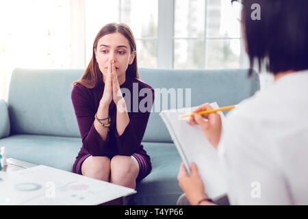 Professionellen Psychologen sorgfältig Notizen während einer Behandlung Interview Stockfoto