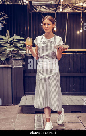 Junge Frau salzen Essen für die Gäste begeistert Stockfoto