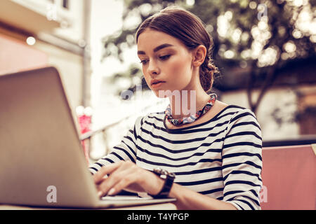 Schön ernsthafte junge Frau Arbeiten am Laptop Stockfoto