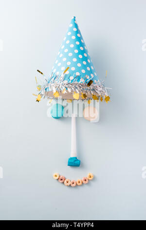 Junge geburtstag Dekorationen. Blauer Tisch Einstellung von oben mit Muffins, Drinks und Party Gadgets. Hintergrund Layout mit Freier Text. Stockfoto