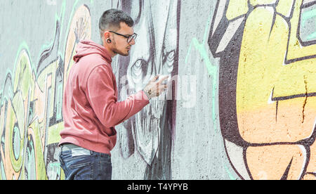 Street Graffiti Künstler Malen mit einem Color Spray kann eine dunkle Monster Schädel Graffiti an der Wand in der Stadt - Urban Lifestyle, Street Art Konzept Stockfoto