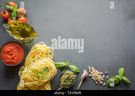 Pasta Zutaten zum Kochen italienische Gerichte - Nudeln, Tomaten, Basilikum, Olivenöl und Knoblauch. Essen Muster. Ansicht von oben mit Platz für Text. Stockfoto