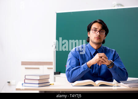 Junge männliche Lehrer vor der Tafel Stockfoto