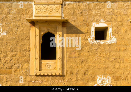 Traditionelle bogenförmige Fenster in einem Sandstein Steinmauer in kumbalgarh Jaisalmer, Rajasthan, Indien. Dieses beliebte Reiseziel ist sagte heimgesucht werden, Stockfoto