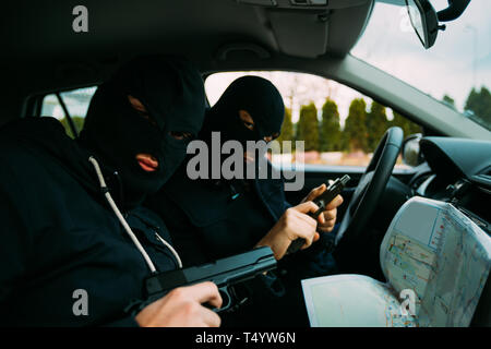 Bankrauber Mit Ihren Masken Auf Und Zeigte Auf Die Karte