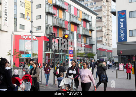 Fußgänger High Road, Wembley, vor einer modernen Einkaufs- und wohnraumentwicklung im Wembley Central. Stockfoto