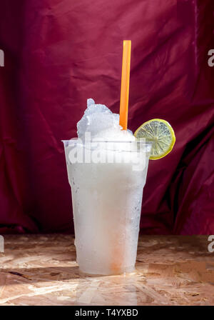 Zitronensaft frappe Obst schmeckt süß und sauer im Glas auf Hintergrund lila Vorhang luxuriöse Stockfoto