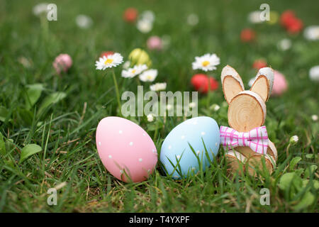 Ostern Jagd - Blau und Rosa Eier und Holz- Bunny in einem Gras Stockfoto