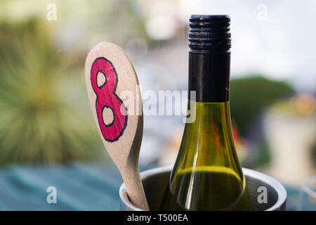 Eine Flasche Wein in einem Weinkühler mit einem Löffel aus Holz Tisch in einer Kneipe Garten chillen Stockfoto