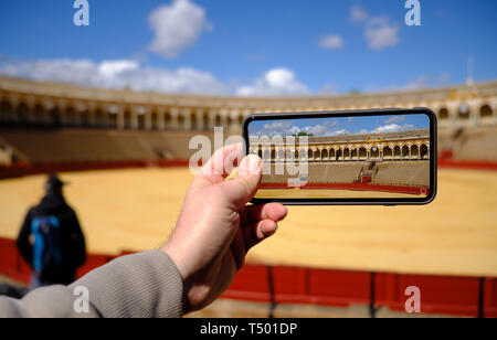 April 2019 Hand ein Foto mit Smart Phone, Stierkampfarena (Plaza de Toros) in Sevilla, Real Maestranza de Caballeria de Sevilla, Spanien - Stockfoto